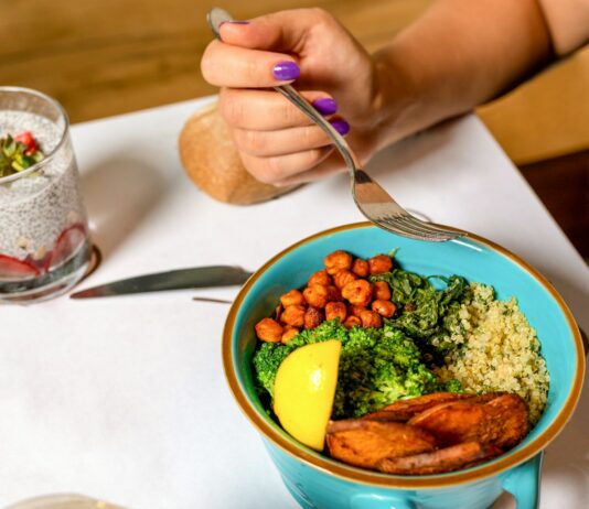 비만을 예방하는 자연식 식단 person holding spoon with food in blue ceramic bowl