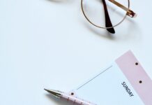 근육량 증대를 위한 운동과 영양 조절 eyeglasses near paper and ballpoint pen