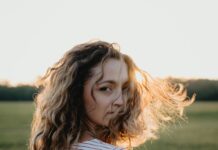 내 안의 건강 시계를 되돌리다: 2025년 최신 웰니스 트렌드 총정리 Woman with curly hair in a field at sunset