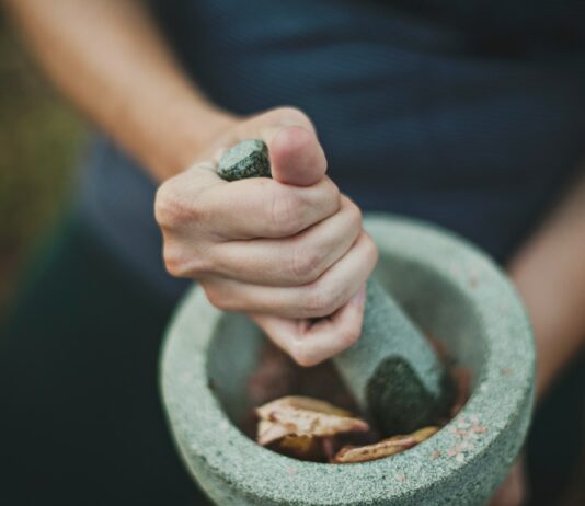 웰빙 시대의 선택, 대체요법이 각광받는 이유와 최신 트렌드 person grinding on mortar and pestle