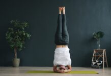 역립 요가: 세상을 거꾸로 보는 용기, 머리 서기 도전 Woman performing a headstand yoga pose indoors.
